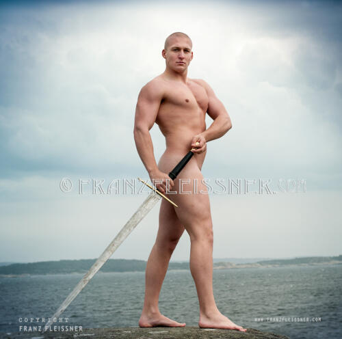Muscled male model posing in outdoors Sweden with a sword